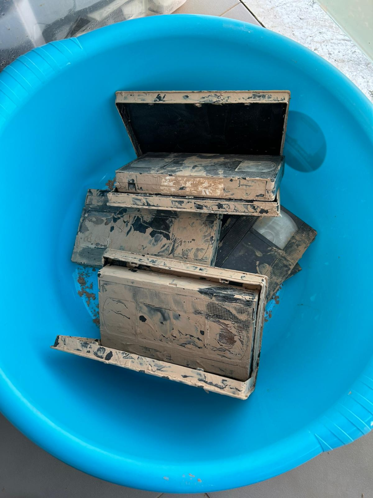 Cintas VHS secándose al sol en un balcón tras ser recuperadas del barro por la riada.