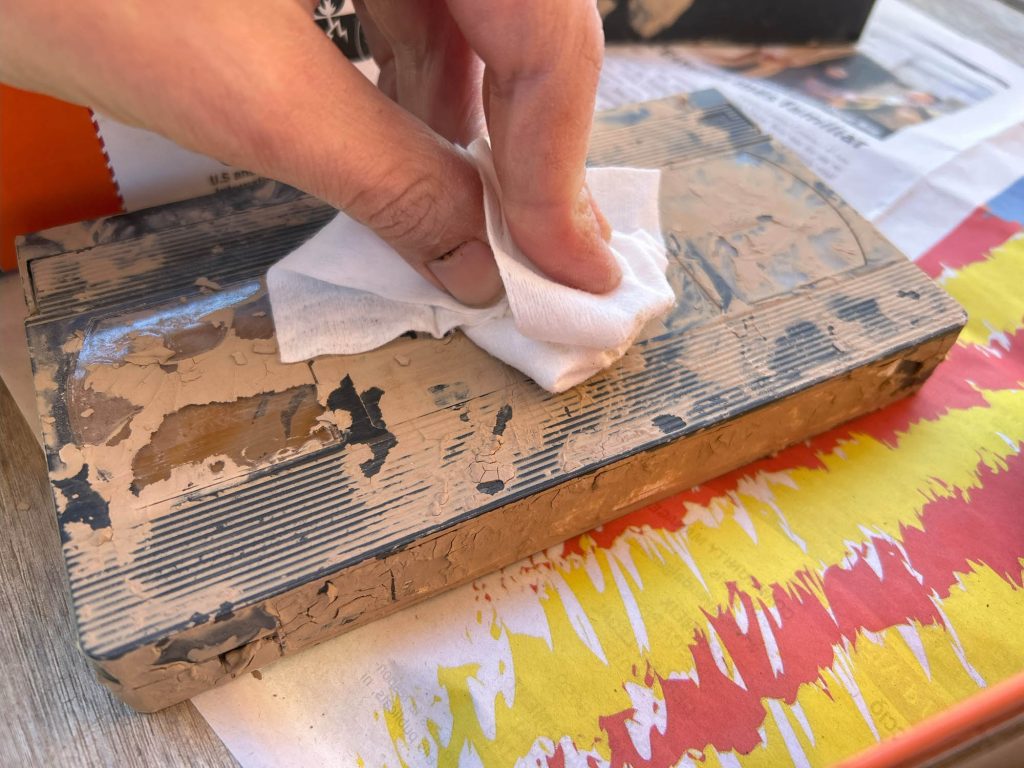 Limpieza exterior de una cinta VHS con una toallita húmeda, retirando el barro tras las inundaciones.